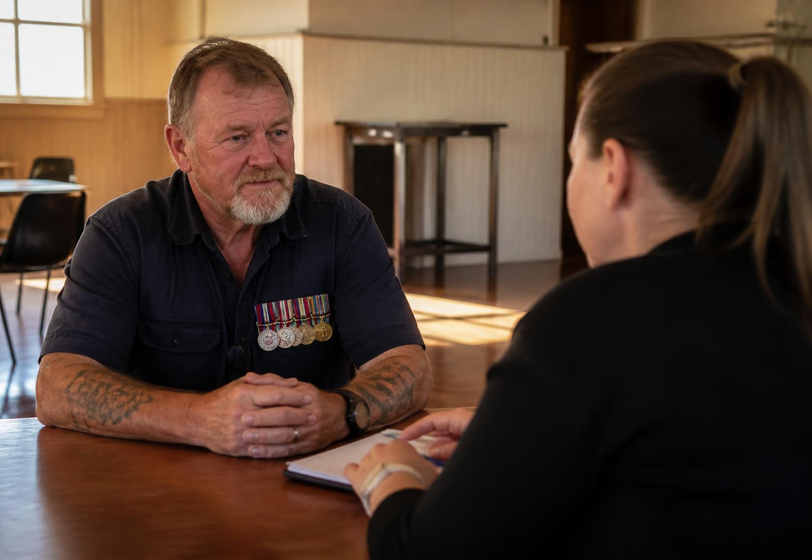A veteran talking with a Rally Point support worker in a Darling Downs community hall